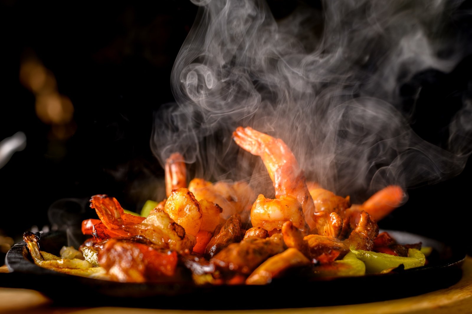 Shrimp and vegetables arriving hot on a sizzling skillet