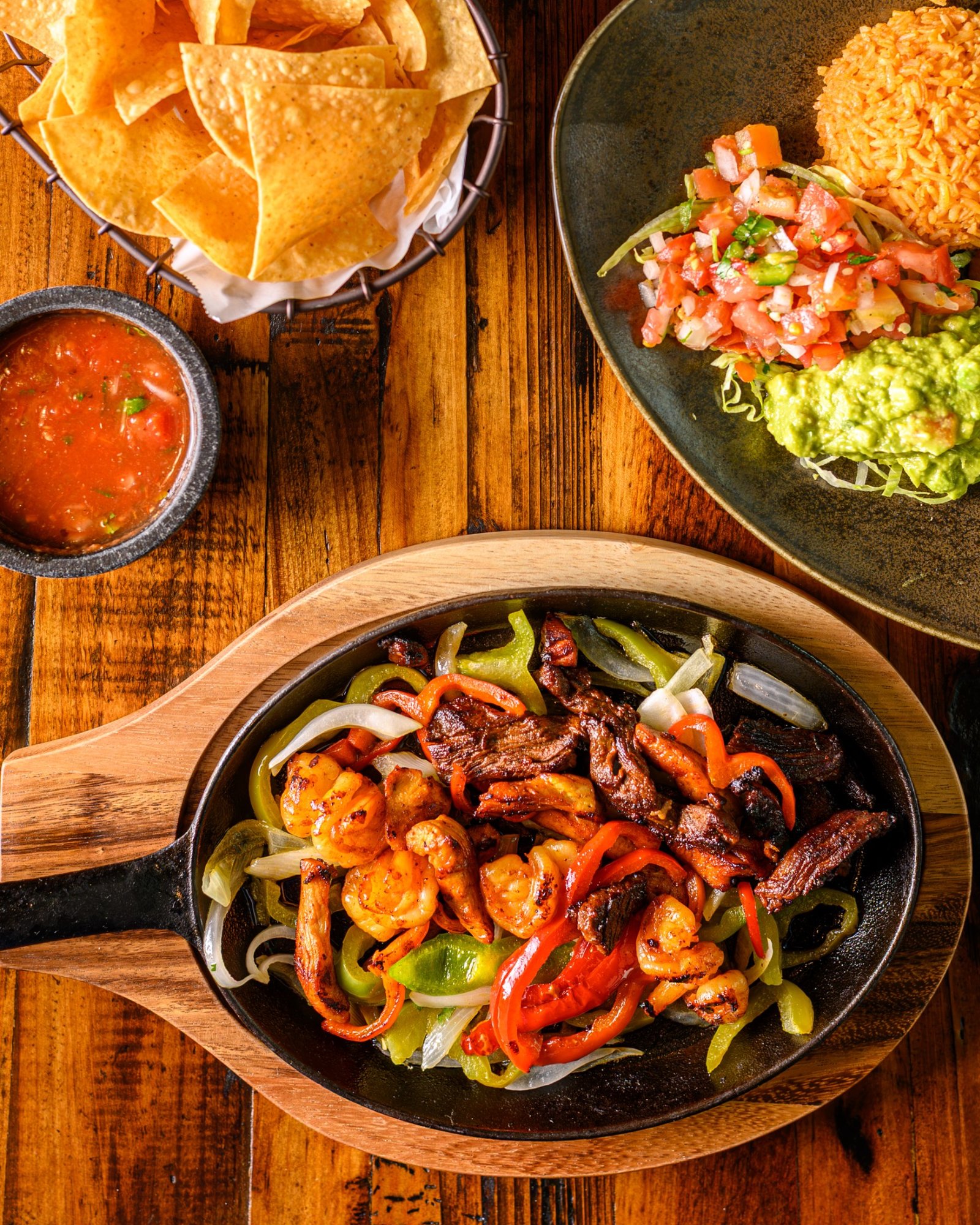 Don Perico fajitas with chips, salsa, rice, pico de gallo, and guacamole